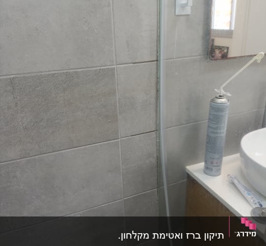 מיכל ספריי ליד כיור בחדר אמבטיה